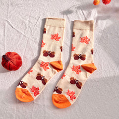 Pair of socks with autumn-themed design on a light background
