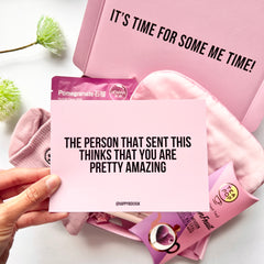 Pink gift box with self-care items and a greeting card reading 'the person that sent this thinks that you are pretty amazing'.